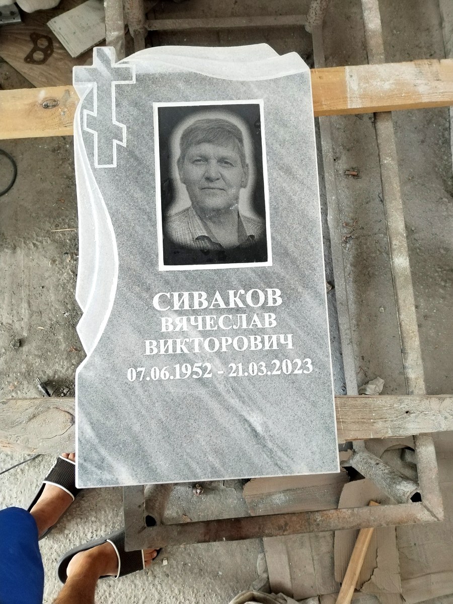 Памятник из мрамора с резным крестом и портретом